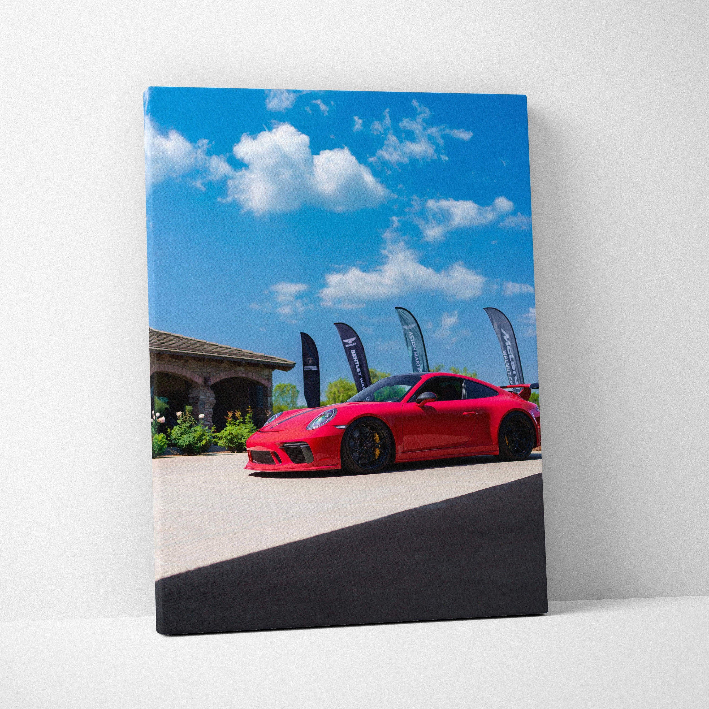Porsche 911 GT3 red sports car against blue sky on vertical canvas wall art.