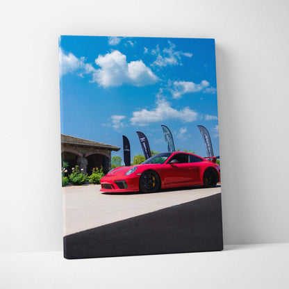 Porsche 911 GT3 red sports car against blue sky on vertical canvas wall art.
