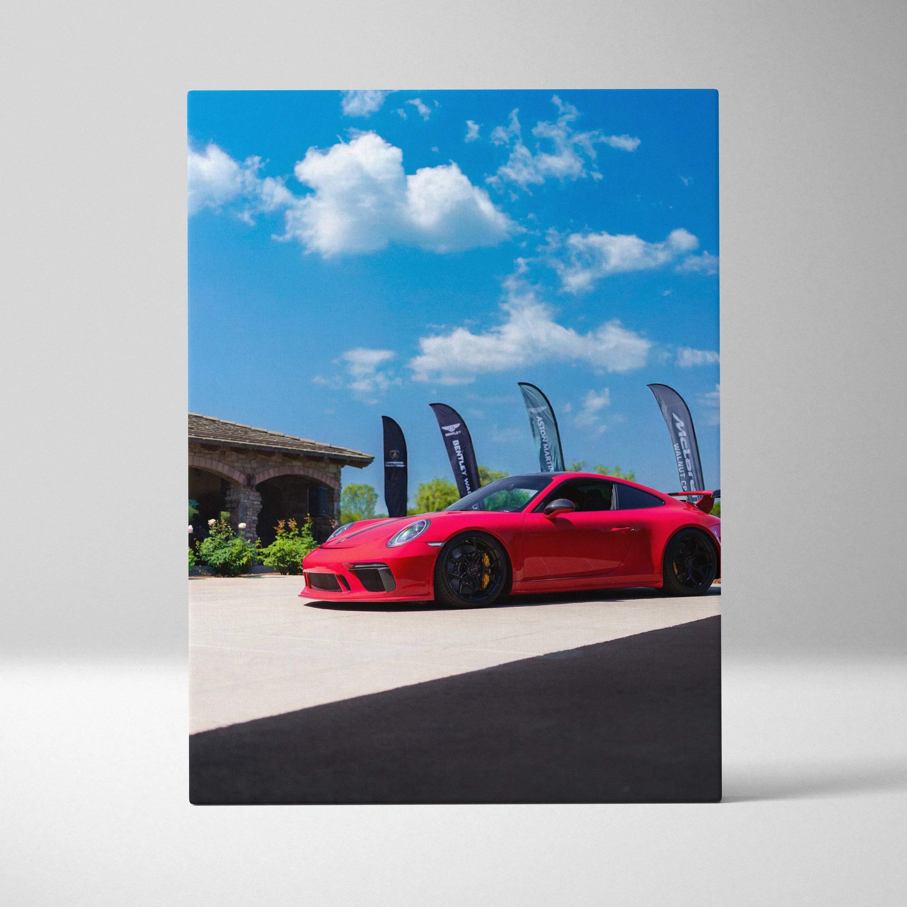 Red Porsche 911 GT3 parked under blue sky with clouds canvas wall art vertical print.