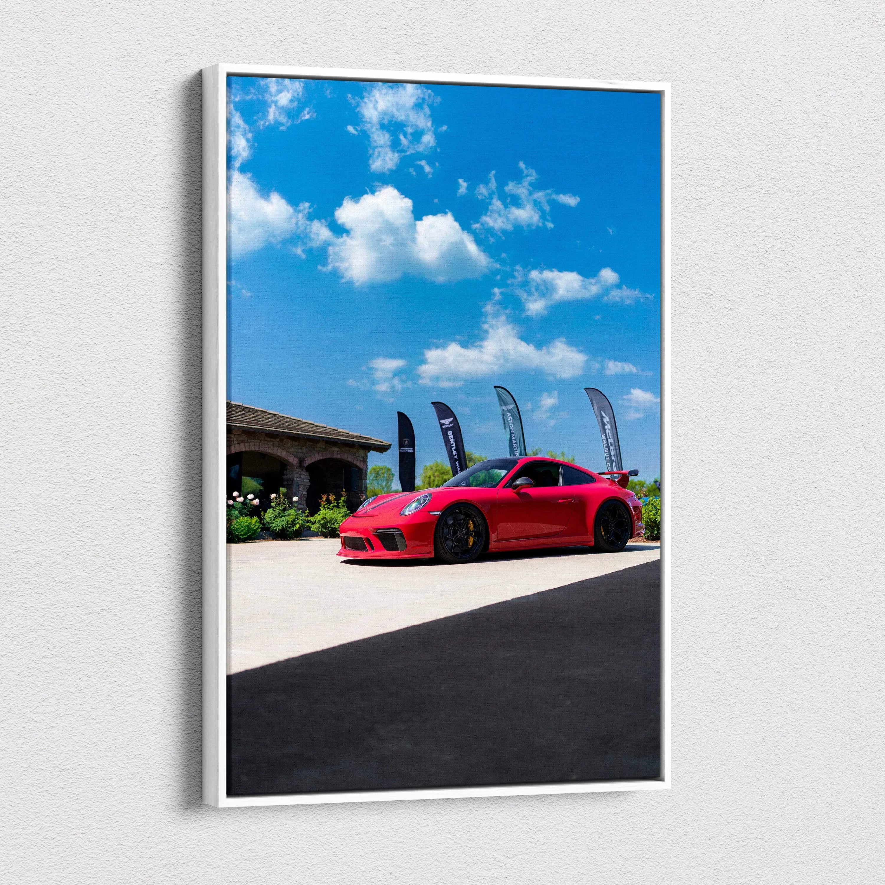Red Porsche 911 GT3 sports car against blue sky on vertical canvas wall art.