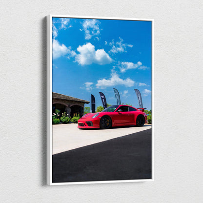 Red Porsche 911 GT3 sports car against blue sky on vertical canvas wall art.