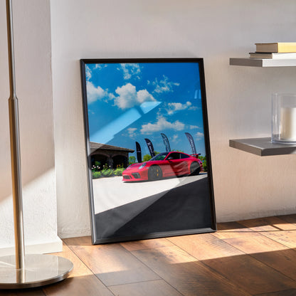 Porsche 911 GT3 red sports car poster with blue sky wall art in black frame.