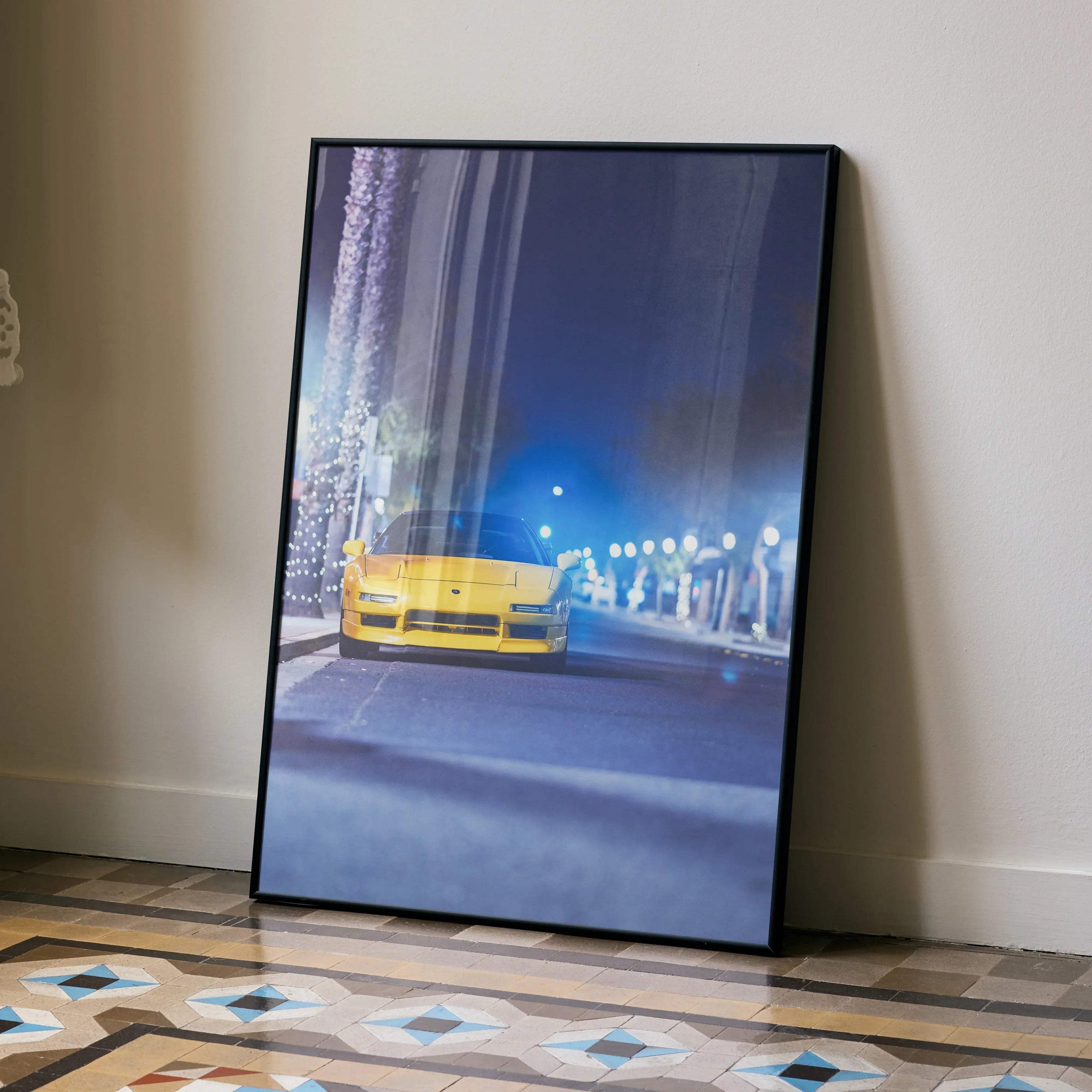 Yellow Acura NSX driving at night in city street poster wall art with black frame.