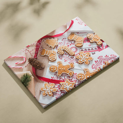Canvas wall art featuring festive gingerbread cookies with white icing on a red and white patterned cloth background.