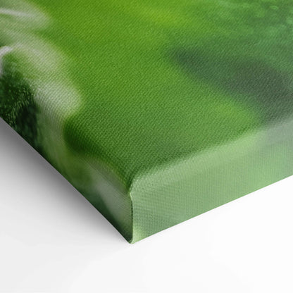 Close-up of canvas wall art with vibrant green leaves and floral design on textured surface.