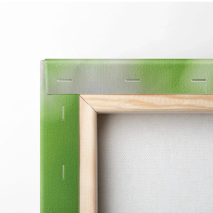 Close-up of stretched canvas with vibrant green leaf print on wooden frame for wall art decor.