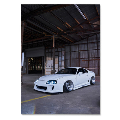 White Toyota Supra MK4 with lowered stance in industrial warehouse setting poster wall art.