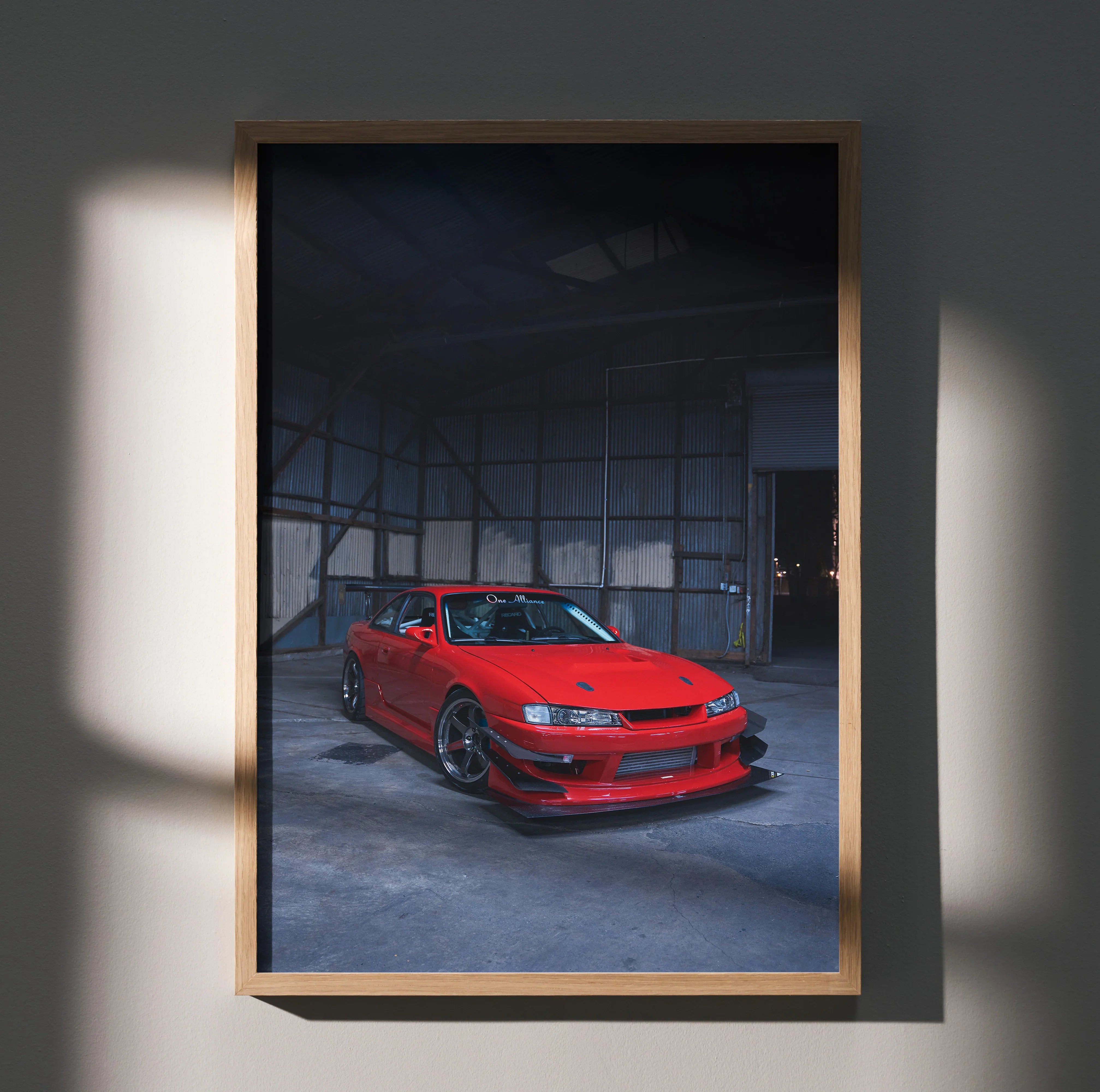 Red Nissan 240sx S14 Kouki car poster in dark industrial garage wall art with wooden frame.