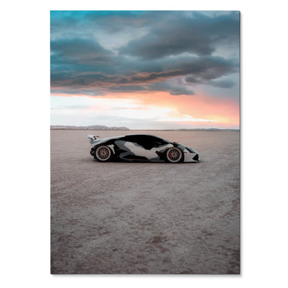 Lamborghini Huracan poster showing sleek sports car with black and white camo design under dramatic sunset sky wall art.