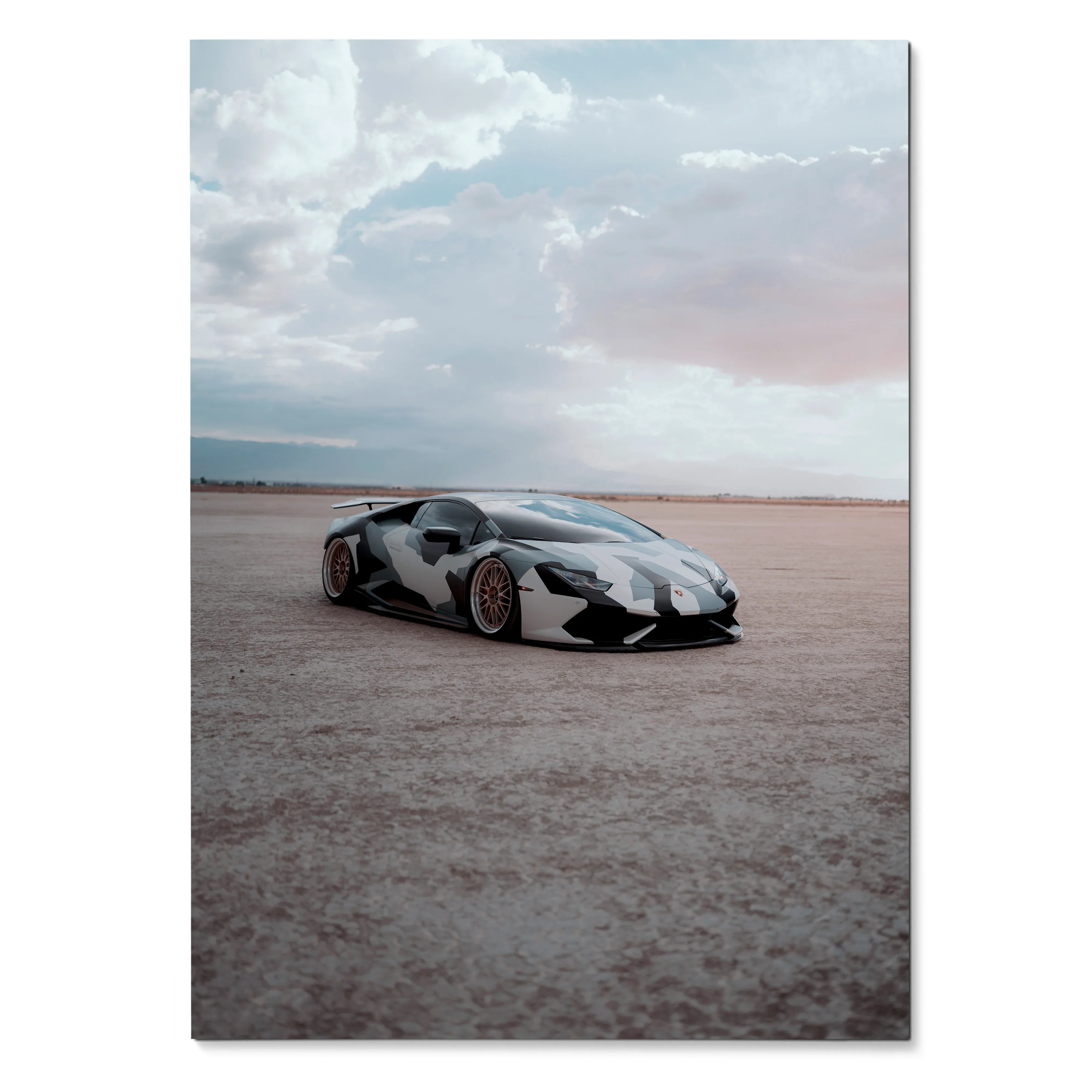 Poster of a sleek black-and-white Lamborghini Huracan parked on a vast open flat under a cloudy sky, wall art.