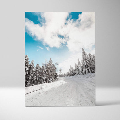 Canvas wall art depicting a snowy winter landscape with frosted trees under a bright blue sky with white clouds.