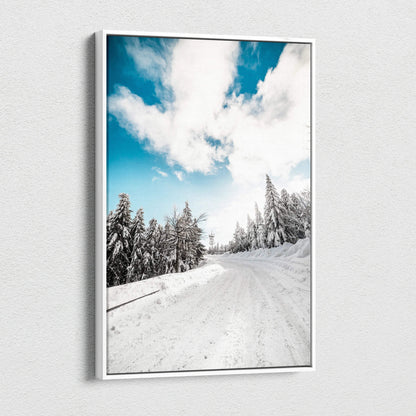 Canvas wall art featuring a snowy landscape with frosted pine trees under a bright blue sky with white clouds.