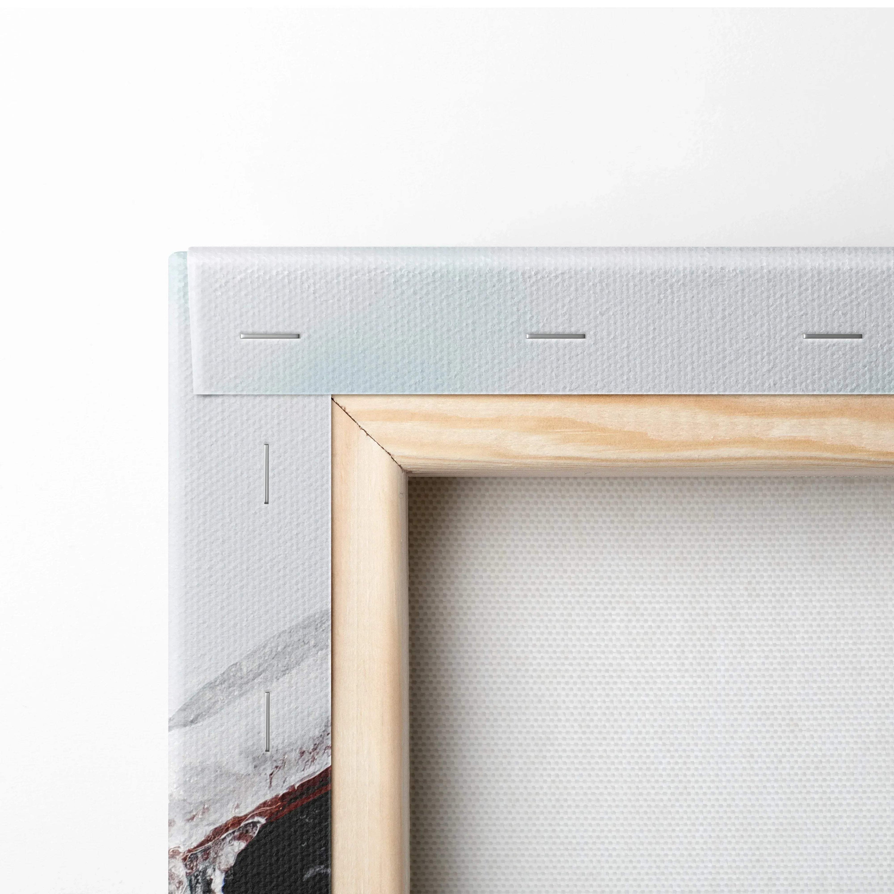 Close-up of a gallery-wrapped canvas print with white edges and a wooden frame backing.