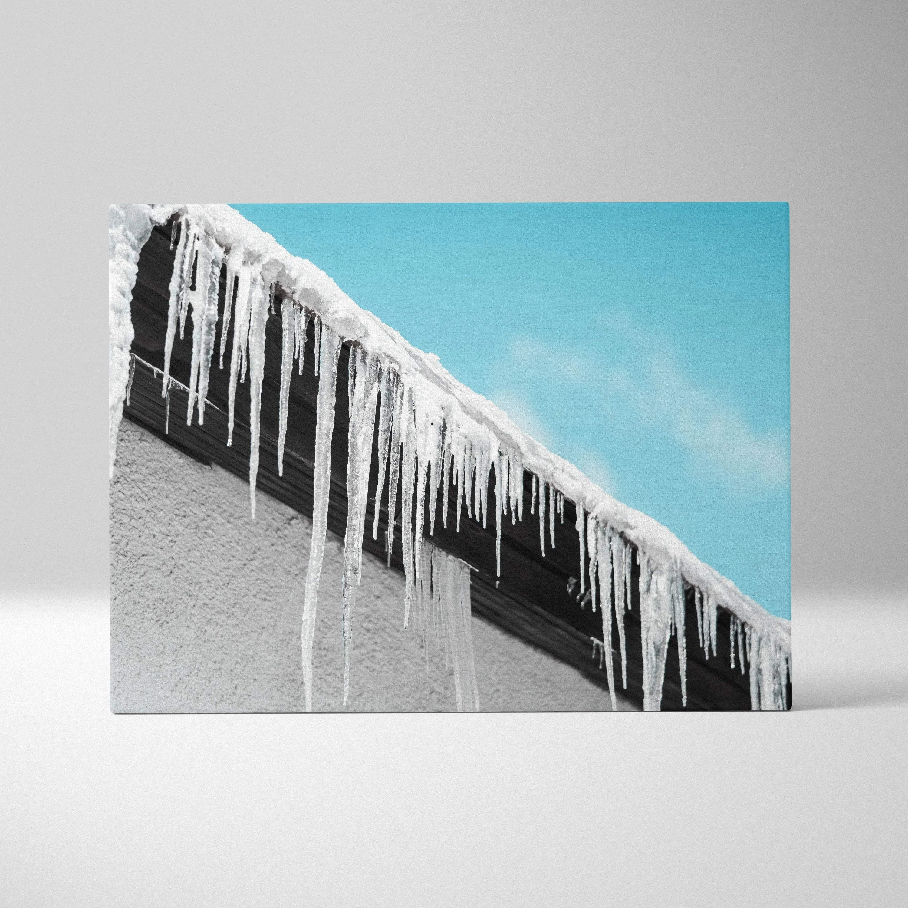 Canvas wall art featuring detailed winter icicles hanging from a snow-covered roof against a clear blue sky background.