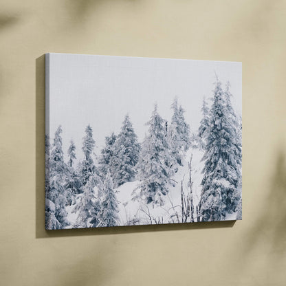 Canvas wall art featuring a high-resolution snowy forest scene with snow-covered evergreen trees in soft blue and white.