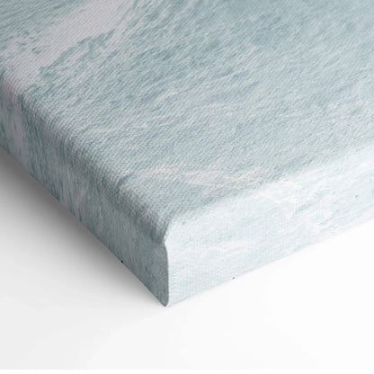 Corner of stretched canvas wall art with textured surface in soft blue and white tones.