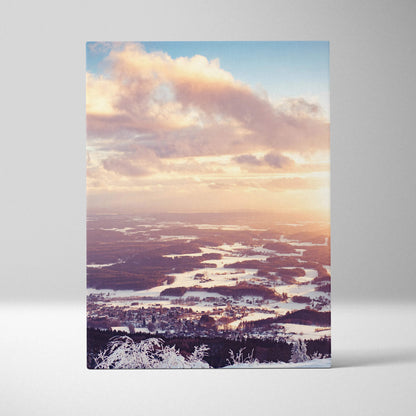 Canvas wall art depicting a serene snowy landscape at sunset with soft pastel clouds and warm light rays over a frozen river