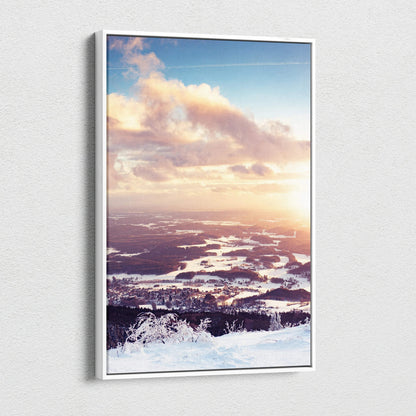 Canvas wall art displaying a snowy winter landscape at sunset with soft pink and orange clouds over a frozen terrain.