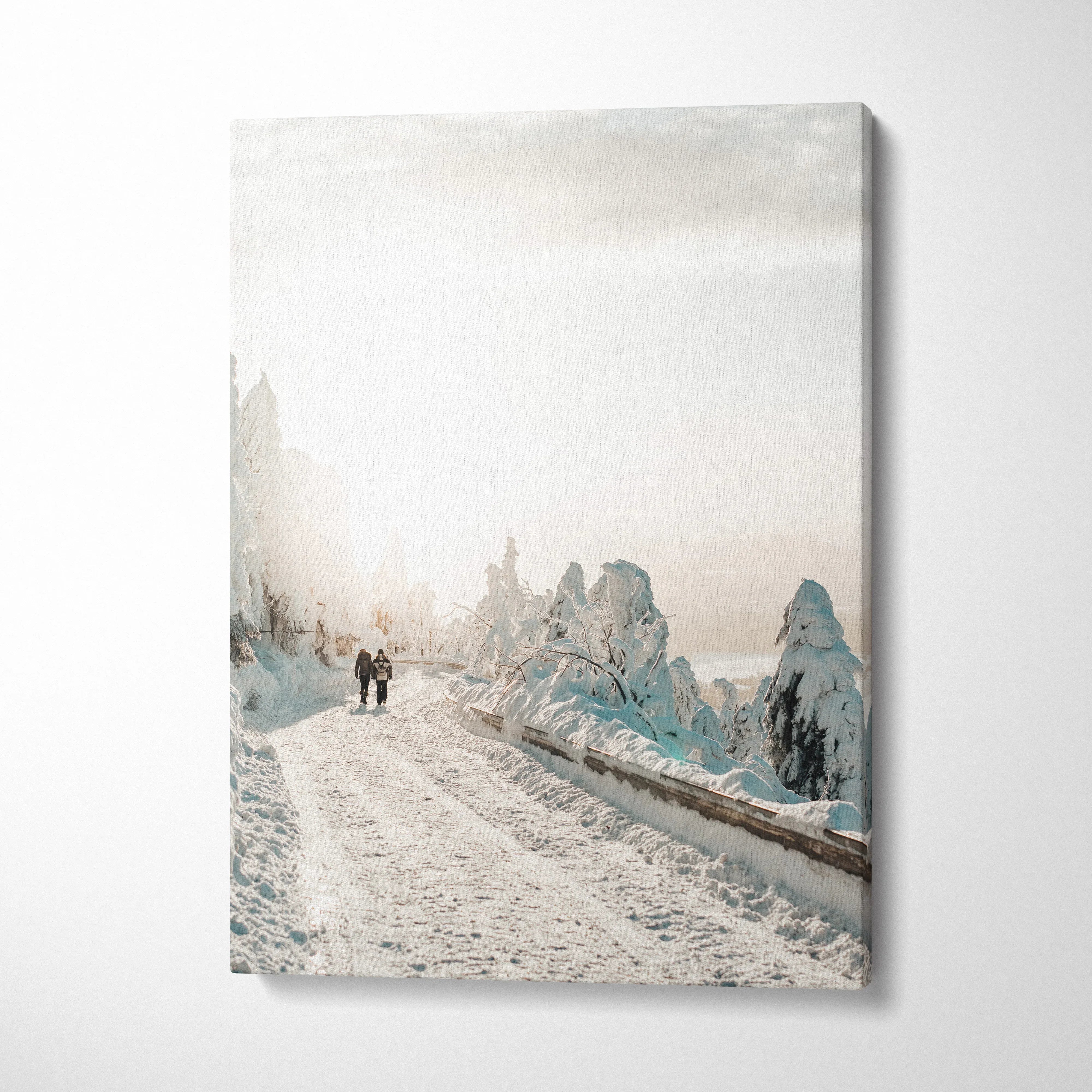 Vertical canvas wall art of a snowy road with frosted trees and two people walking, winter decor.