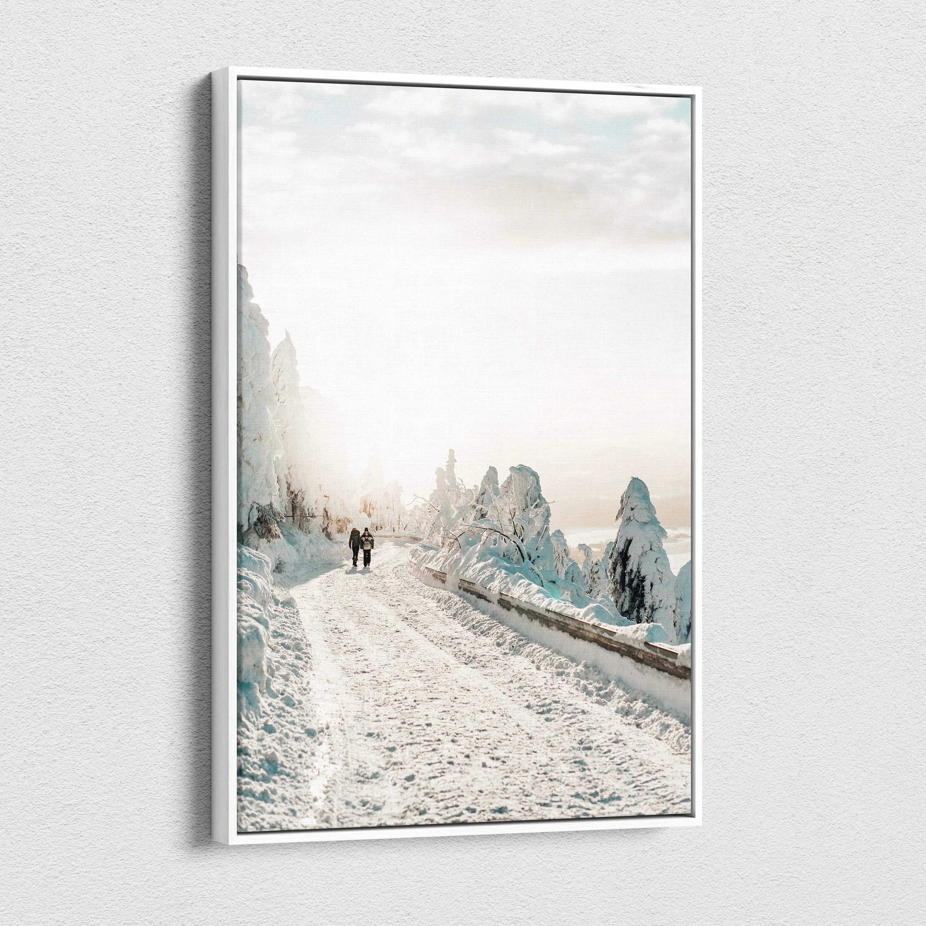Canvas wall art depicting a snowy road winding through frost-covered trees under a soft, cloudy sky.