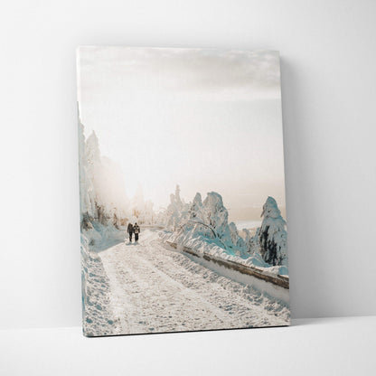 Canvas wall art depicting a serene snowy road with frosted trees under a pale sky, muted color palette.