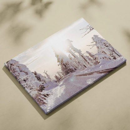 Canvas wall art featuring a snowy winter landscape with sunlit trees and a pale sky.