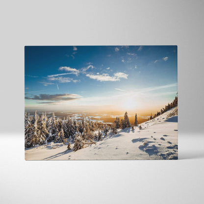 Winter landscape digital canvas wall art featuring snow-covered trees under a bright blue sky at sunset.