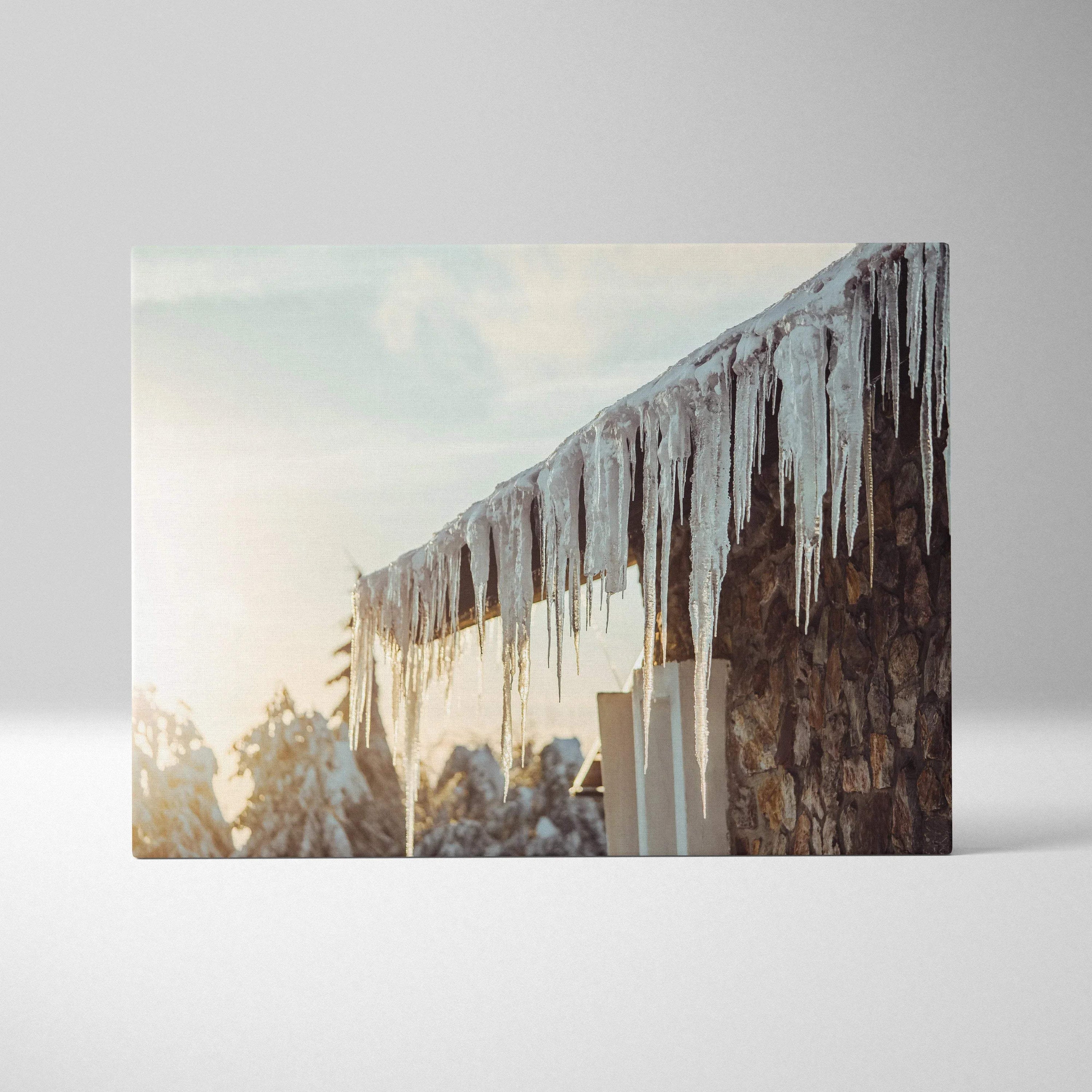Canvas wall art featuring detailed digital winter scene with long glistening icicles hanging from rustic roof against soft.