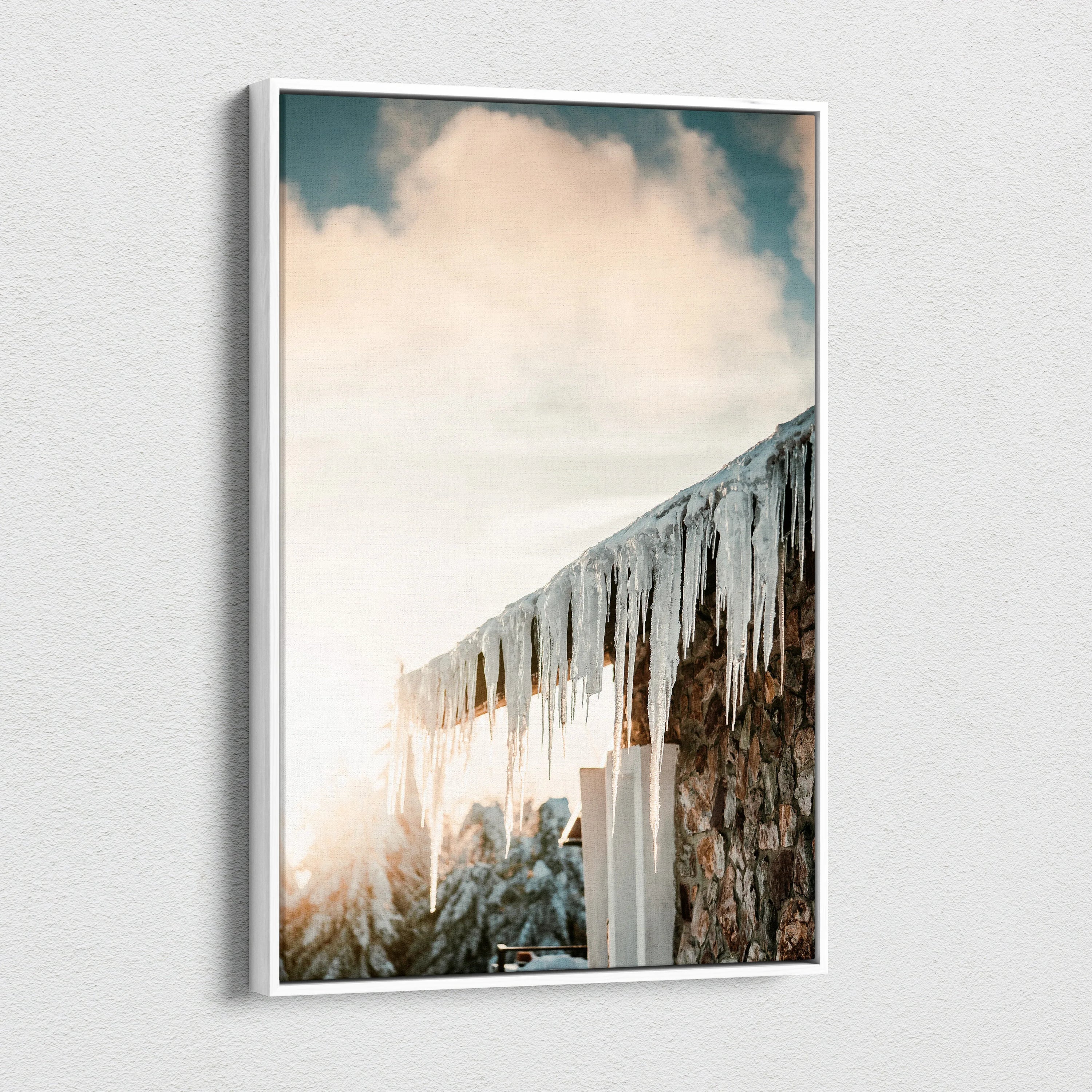 Canvas wall art featuring a snowy landscape with wooden roof and glistening icicles under a soft cloudy sky.