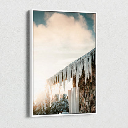 Canvas wall art featuring a snowy landscape with wooden roof and glistening icicles under a soft cloudy sky.
