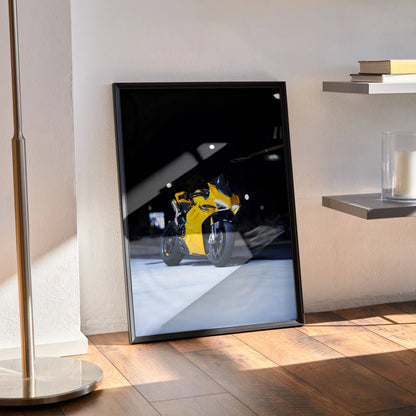 Ducati Panigale V4S motorcycle poster with yellow bike details, black framed wall art leaning on floor.
