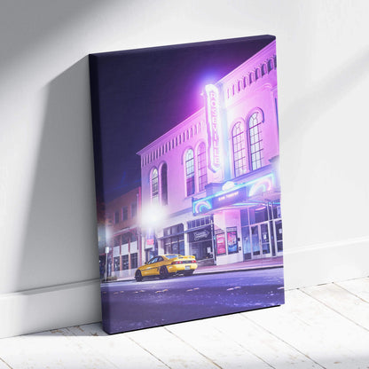 Vertical canvas wall art featuring a glowing neon-lit vintage theater and a yellow taxi at night.