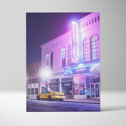 Vertical canvas art of a yellow Toyota MR2 parked outside a neon-lit theater at night, vibrant wall art with cityscape.