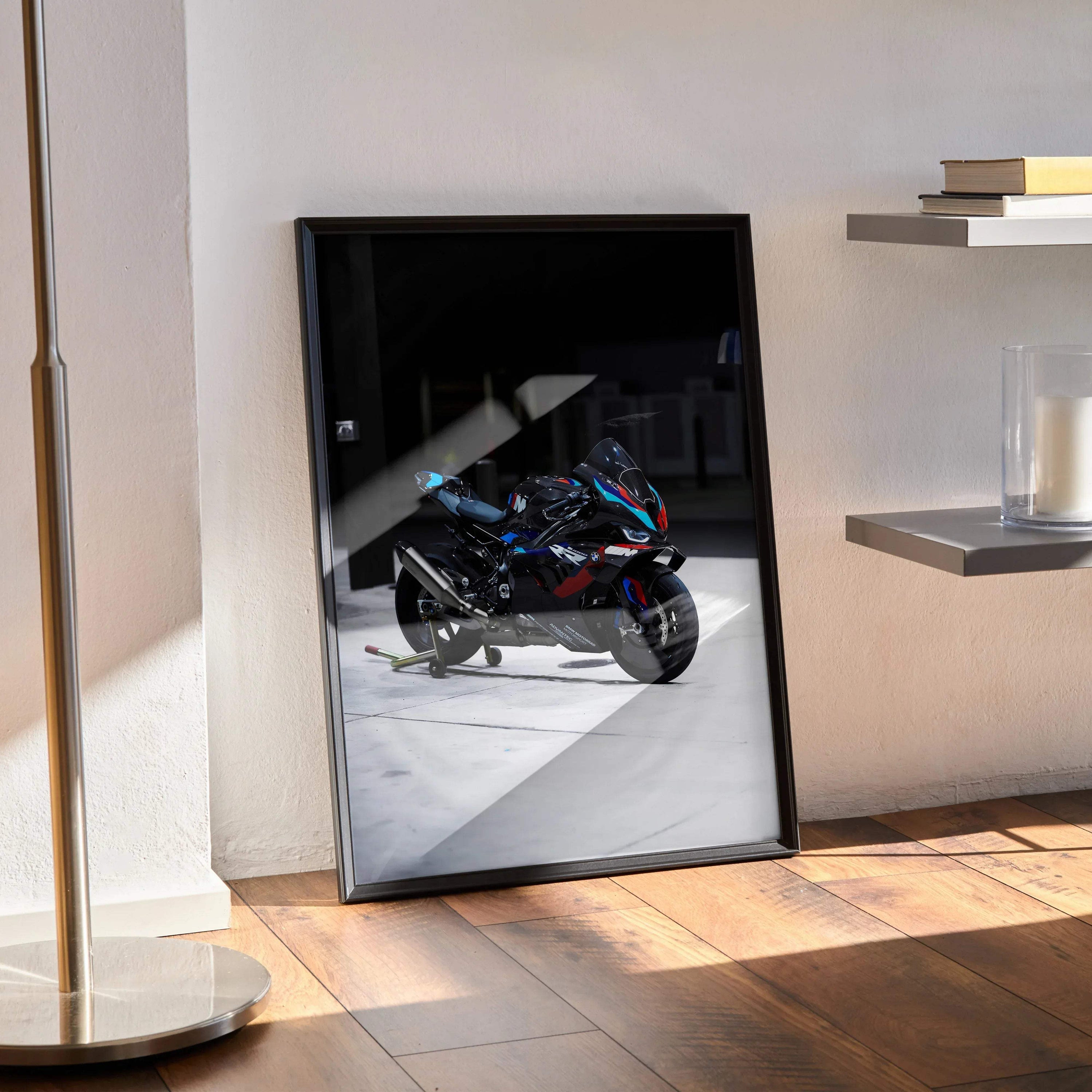 Framed BMW M1000RR motorcycle wall art poster with dark background, leaning against wall.