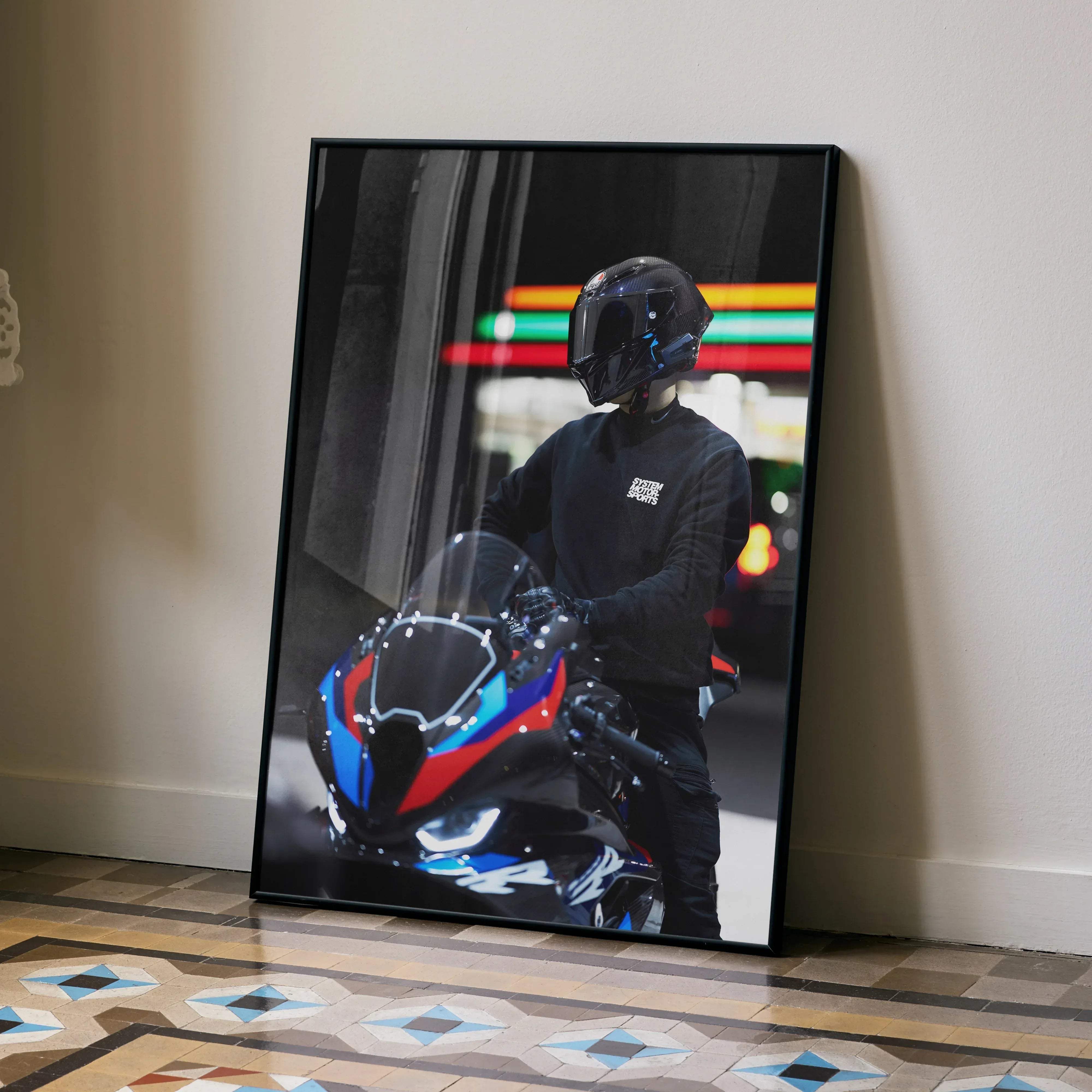 Black-framed canvas print of a motorcyclist wearing an agv pista helmet on a bmw m1000rr with blue and red accents