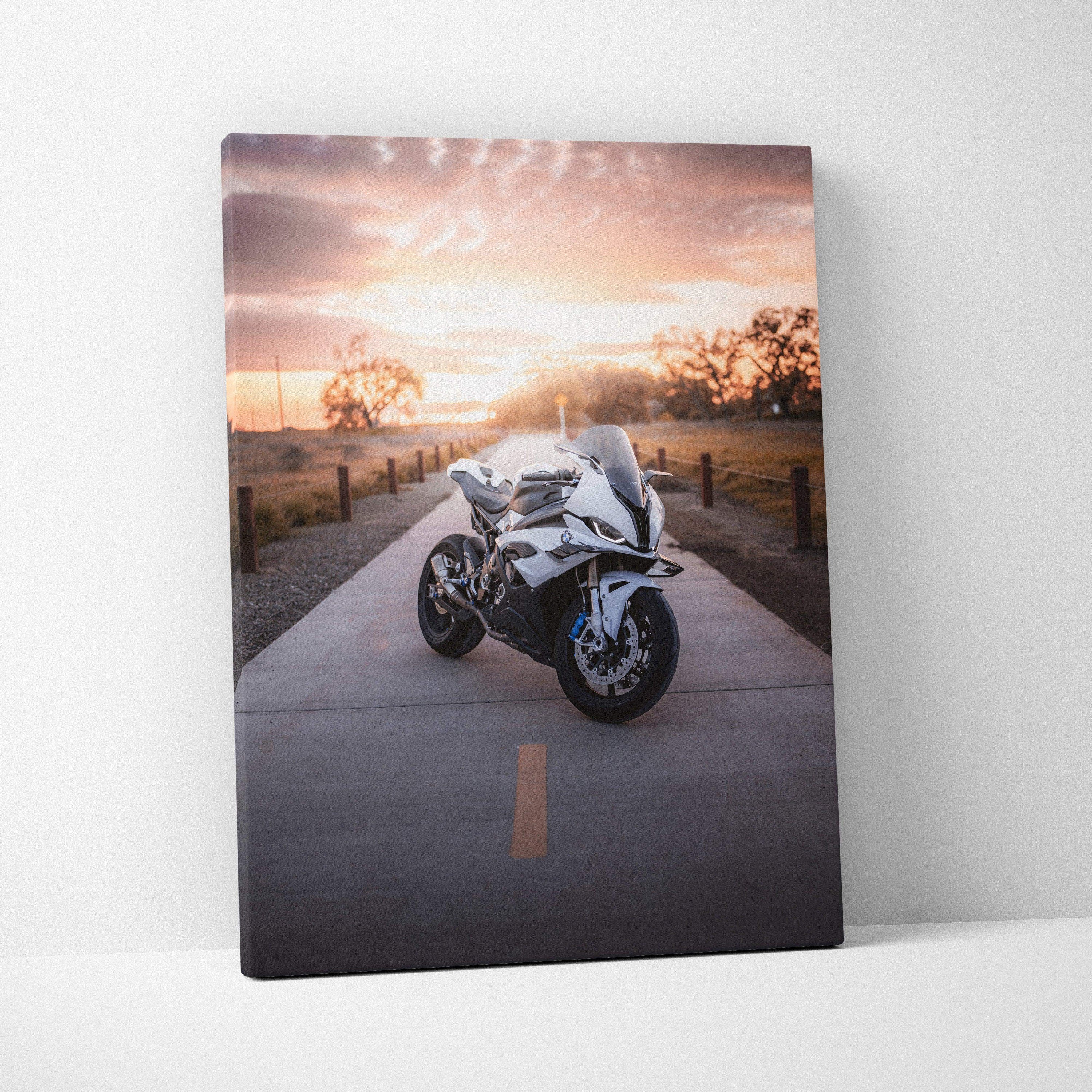Vertical canvas wall art of a white BMW S1000RR motorcycle on a sunset road with warm sky colors.