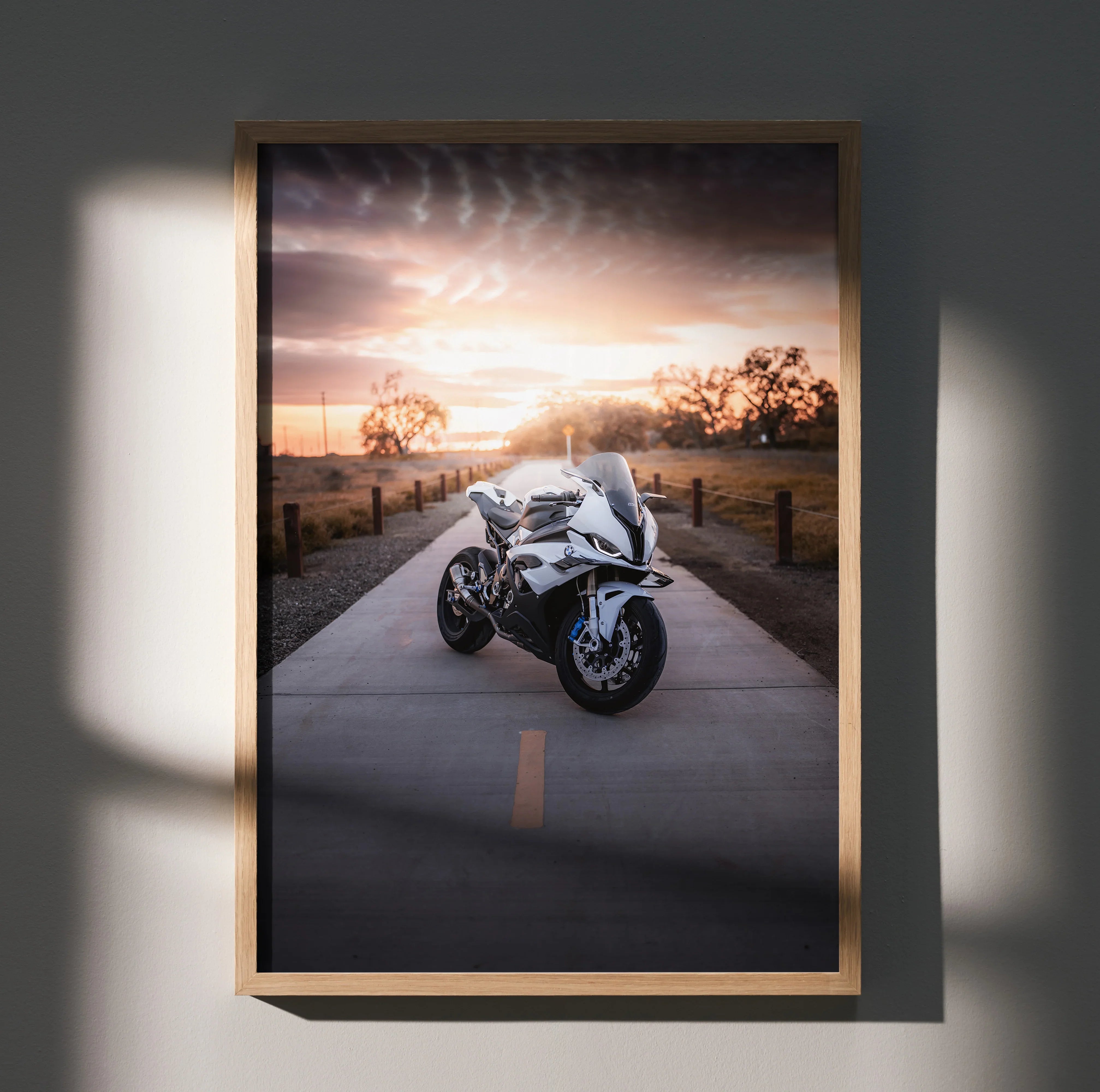 BMW S1000RR motorcycle poster with sunset background, sleek white bike wall art in wooden frame.