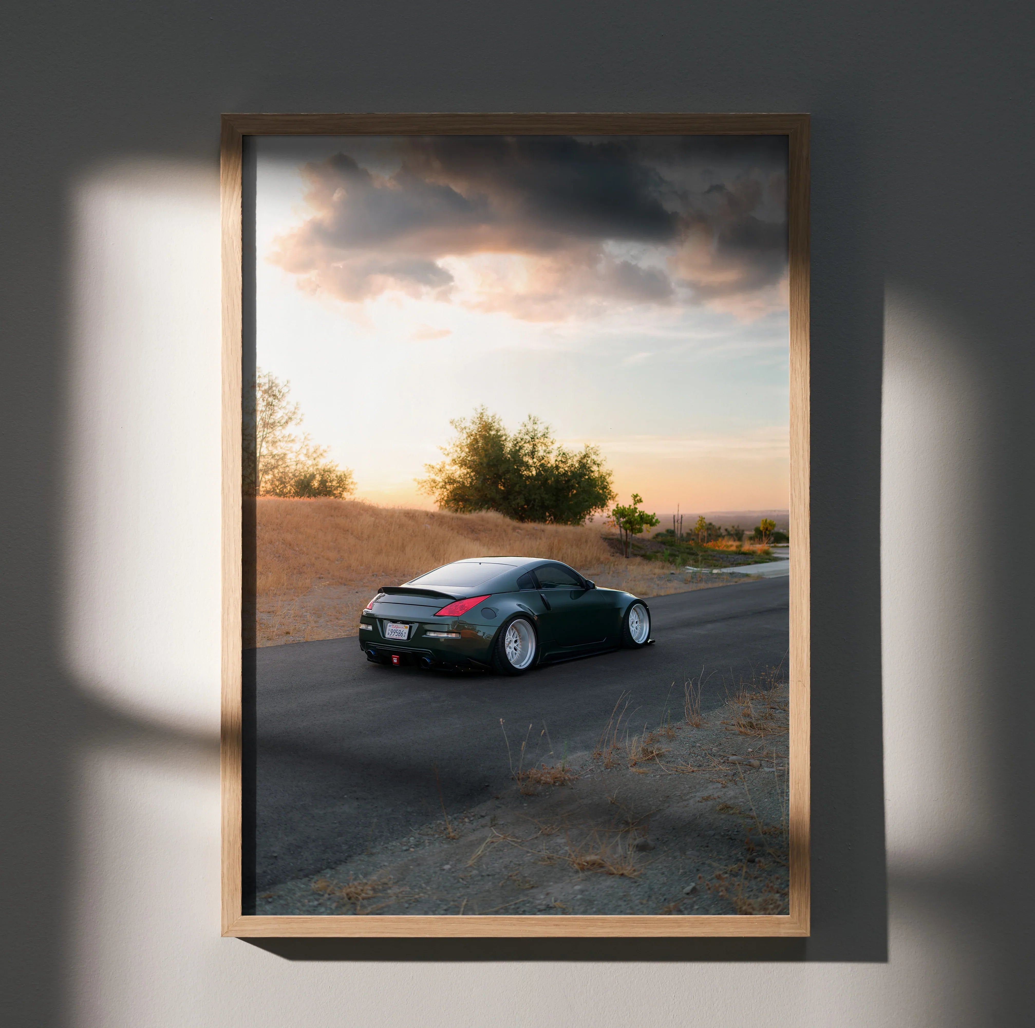Nissan 350z car driving on road at sunset poster wall art in wooden frame.
