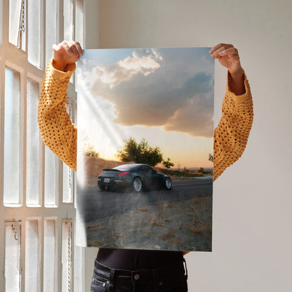 Nissan 350z driving on scenic road at sunset poster wall art in vibrant colors.