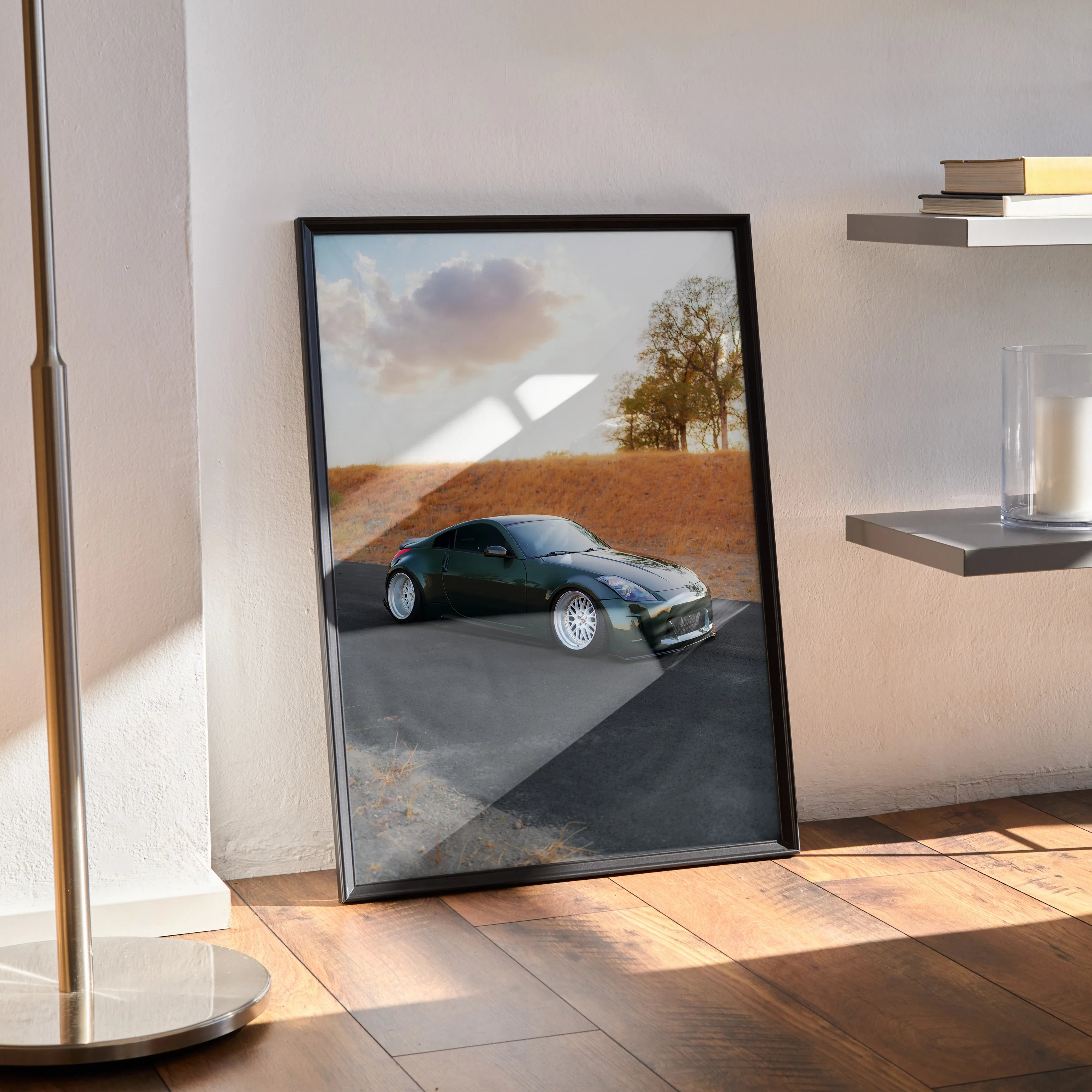 Nissan 350z car poster with scenic desert background, framed wall art leaning on wooden floor.