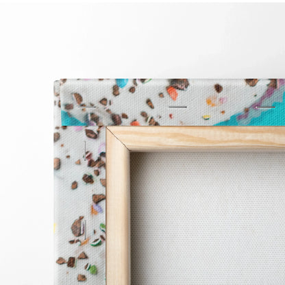 Close-up of wooden frame corner on vibrant donut canvas wall art with colorful sprinkles decor.