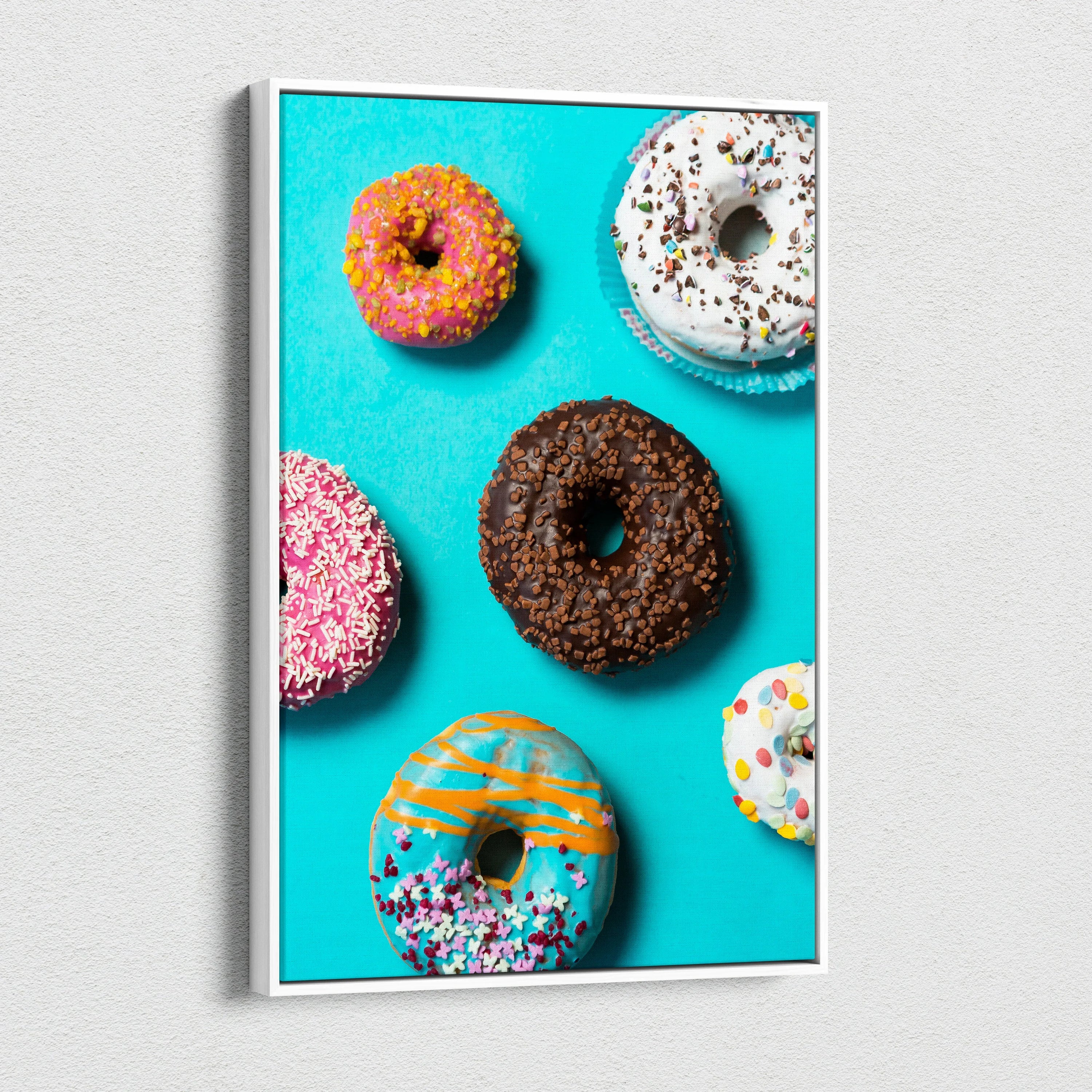 Colorful donut assortment on vibrant blue canvas wall art for kitchen decor.