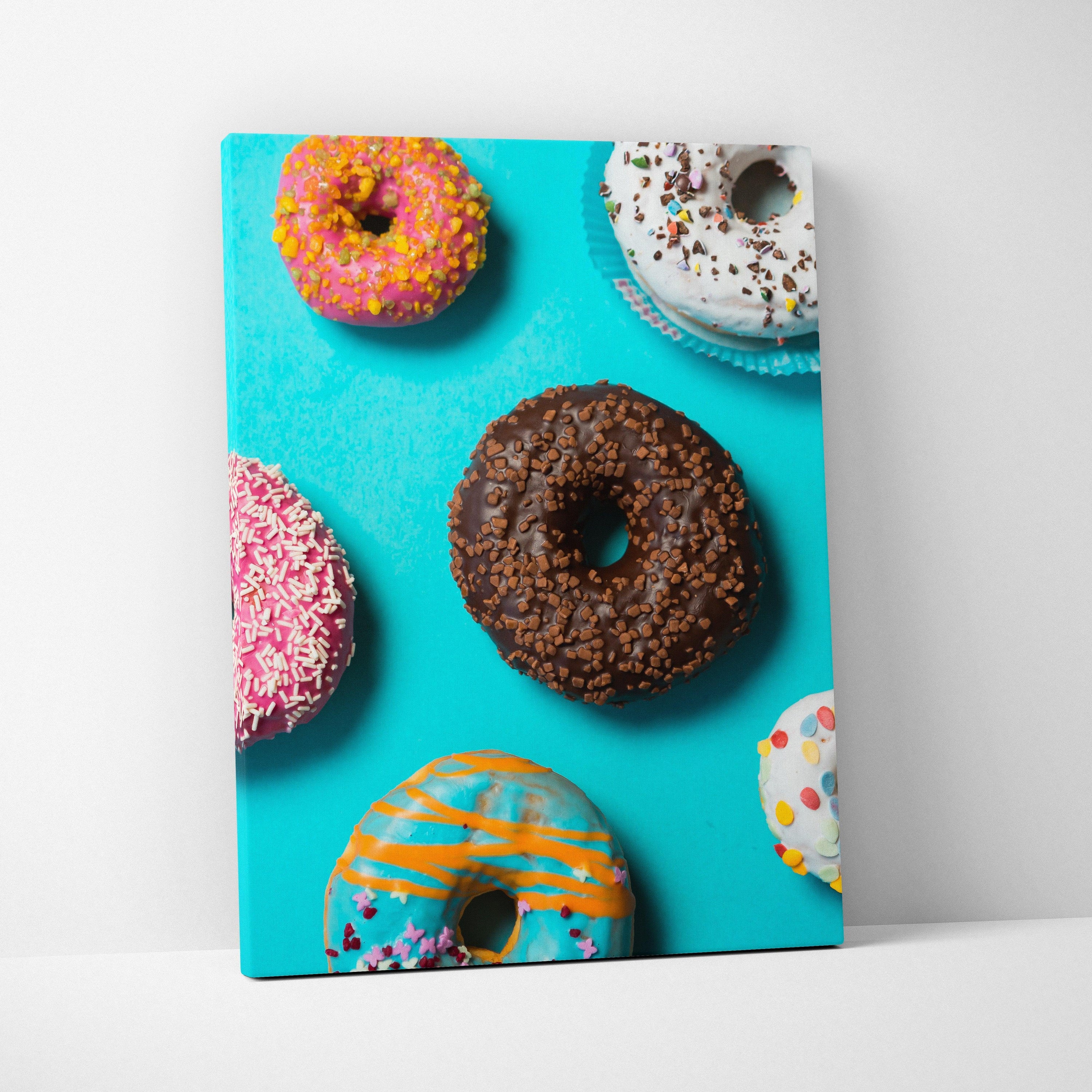 Colorful donut-themed canvas wall art with bright sprinkles on a vibrant blue background.