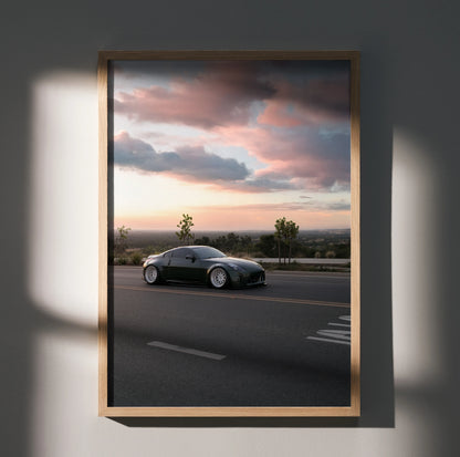 Nissan 350z sleek black car on road under pink and blue sunset sky poster wall art.