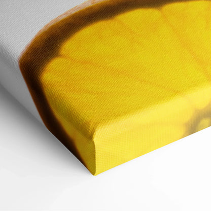 Close-up of canvas wall art corner featuring vibrant yellow lemon slice with textured fabric surface and wrapped edges.