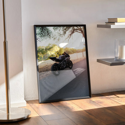 Yamaha R6 motorcycle poster leaning against wall showing black bike on sunlit road with tree shadows, framed wall art.