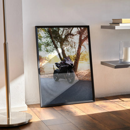 Yamaha R6 motorcycle poster leaning against wall with reflective outdoor scene, framed wall art.