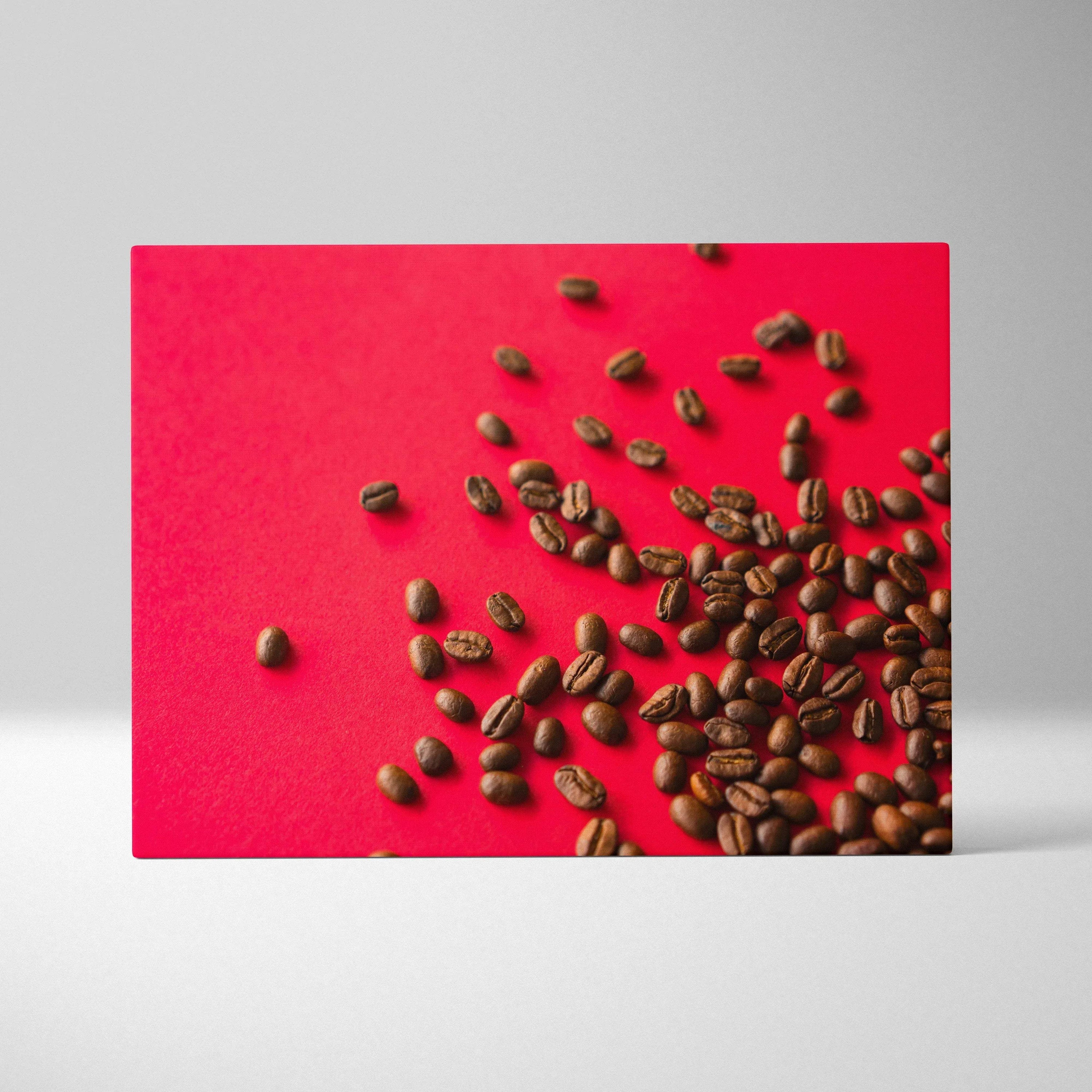 Canvas wall art featuring scattered dark brown coffee beans on a vibrant red background for modern decor.