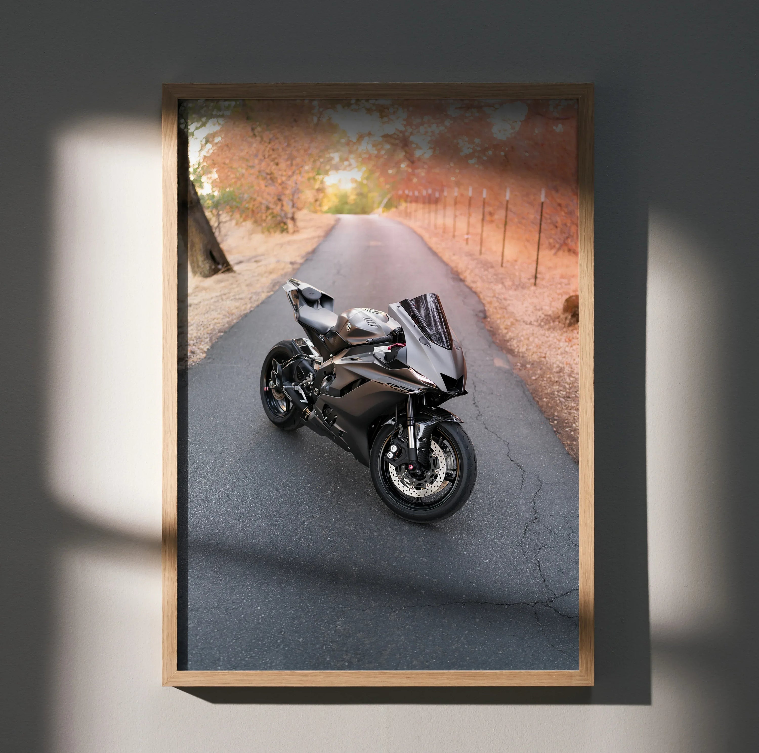 Yamaha R6 motorcycle on a scenic fall road poster wall art framed in light wood.