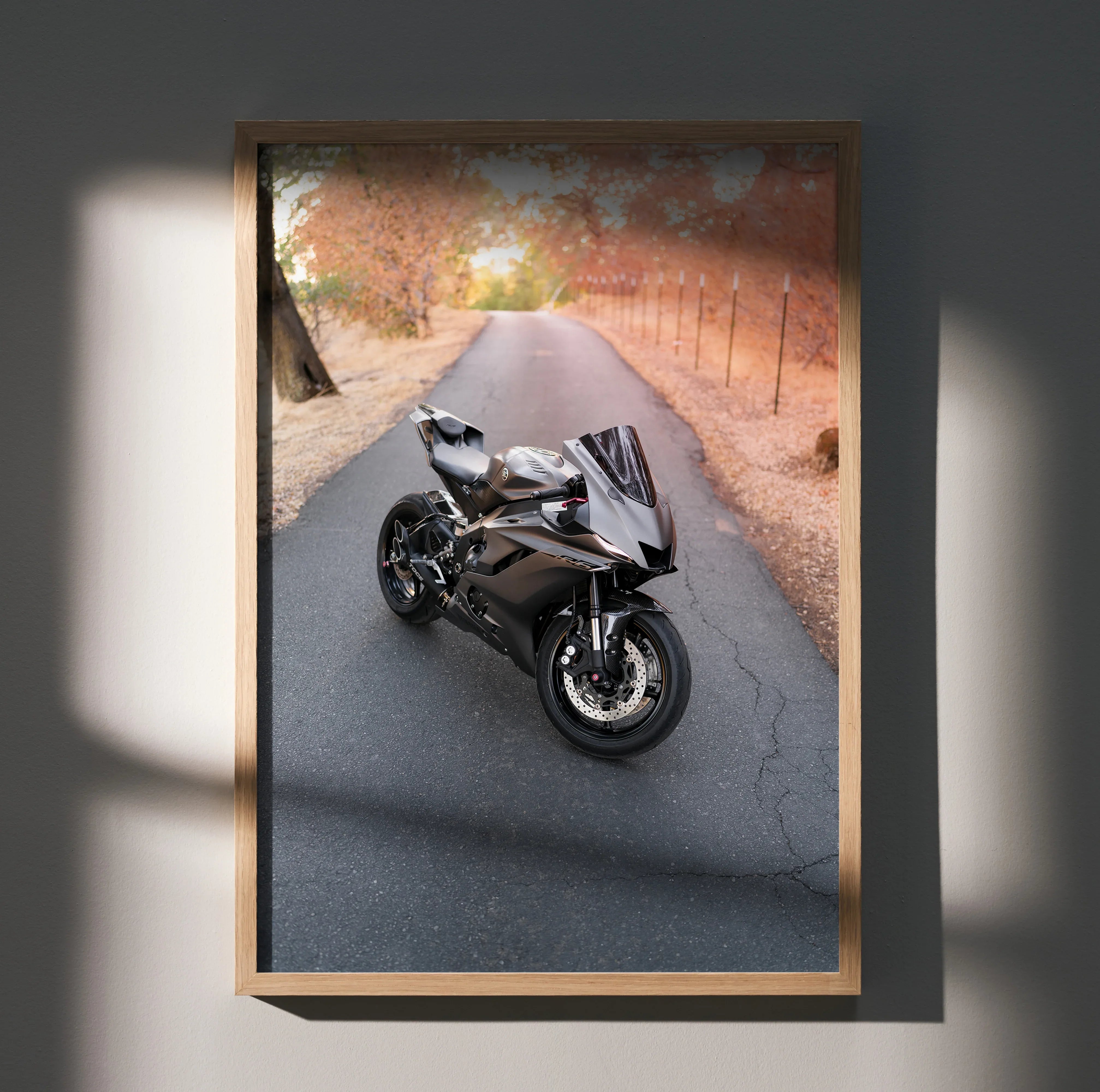Yamaha R6 motorcycle on a scenic fall road poster wall art framed in light wood.